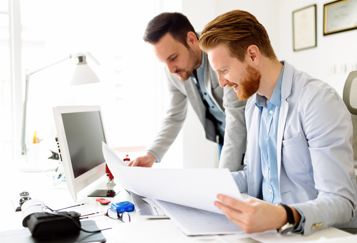 Two professionals in a bright office, talking.