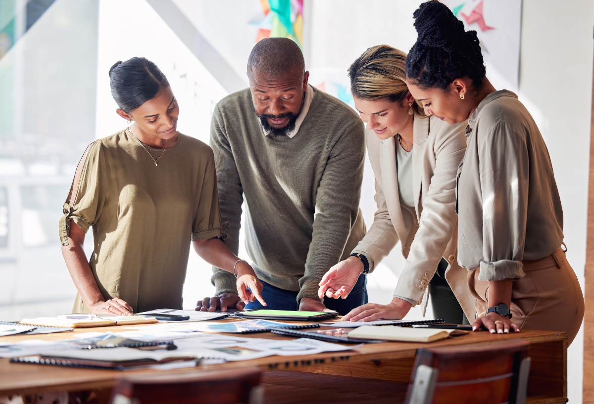 Group of professionals in an office, looking at documents.