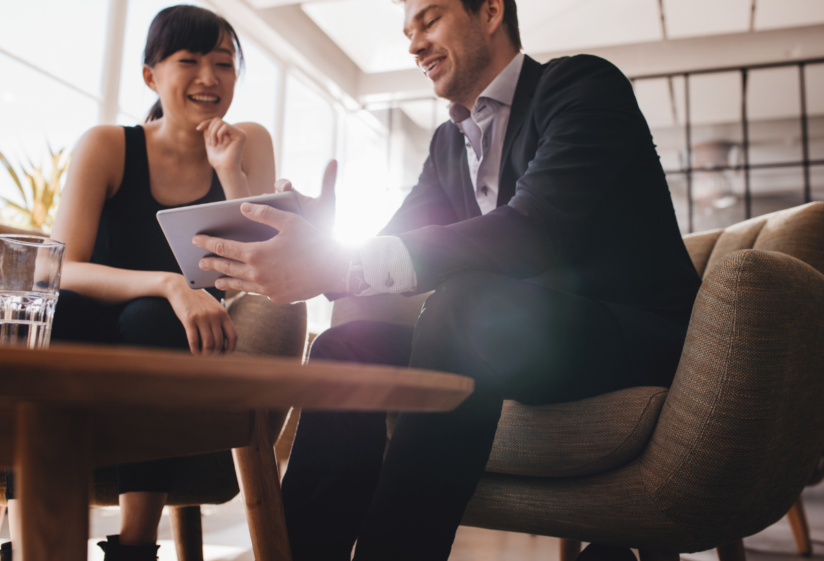 2 professionals in a meeting around a table.