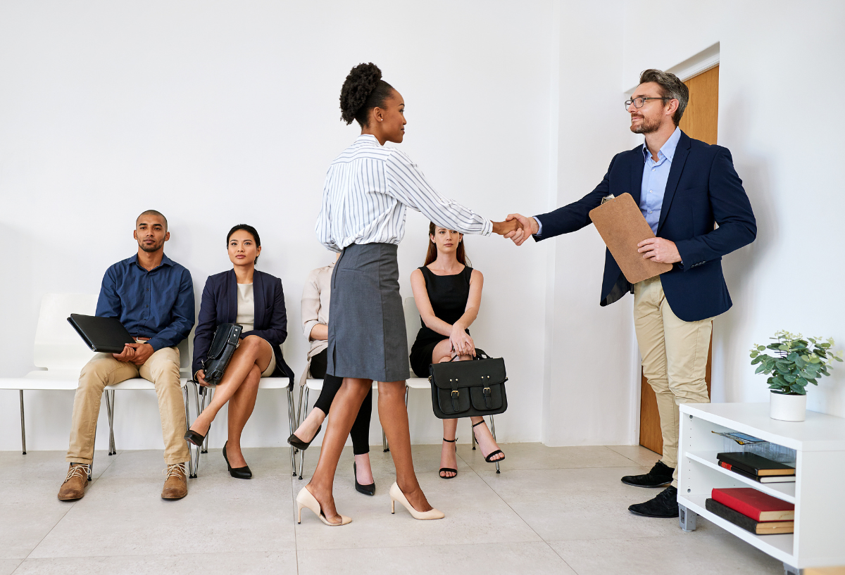Woman in an office, smiling while shaking hands