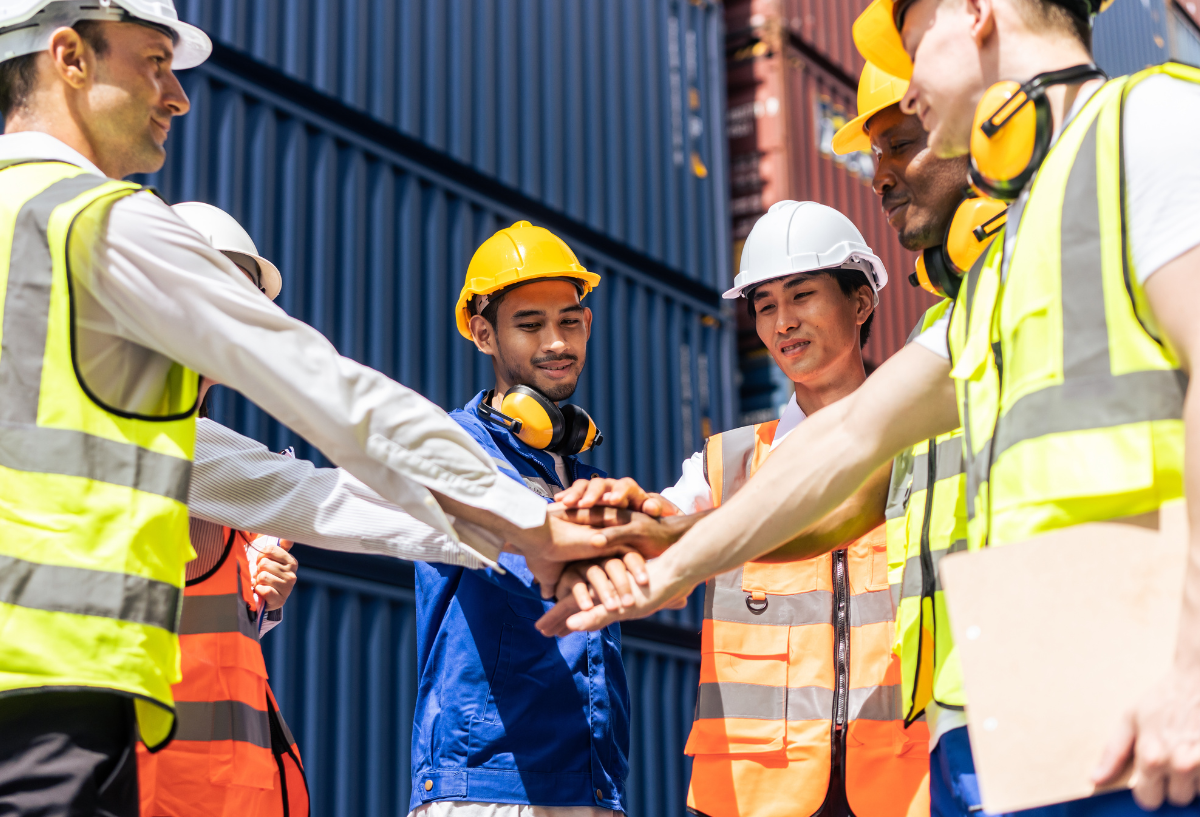 group of people's hands stacked together in teamwork.