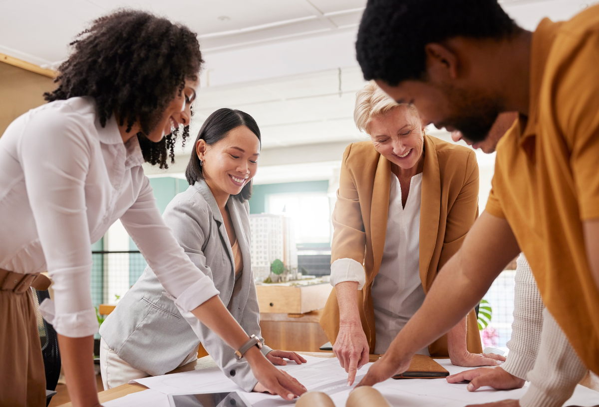 Group of professionals in an office meeting, smiling.