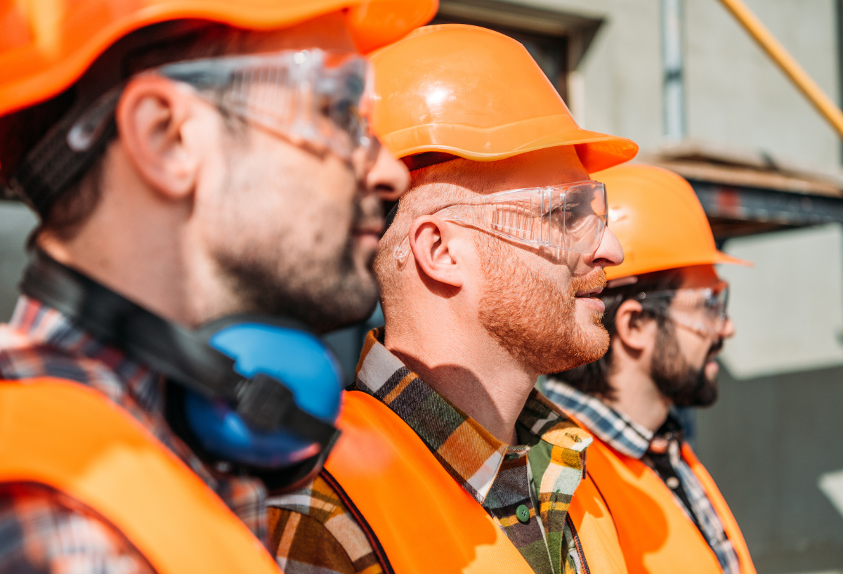 workers in orange hard hats on a construction site.