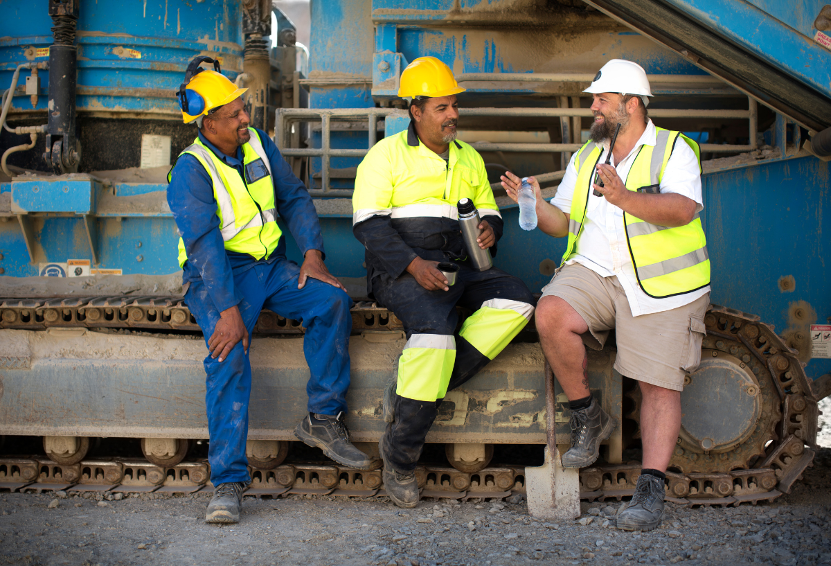 Group of smiling, diverse construction workers in hard hats.