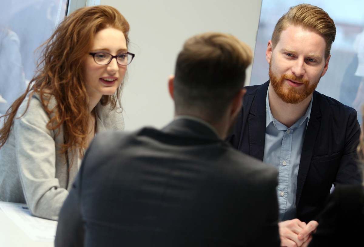 Men and woman in an office, looking at each other.