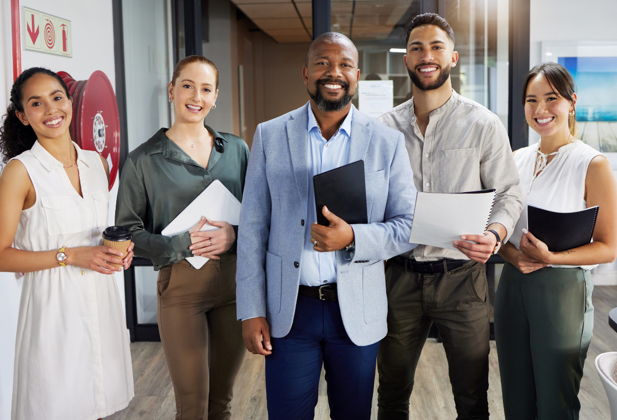 Group of professionals in an office, smiling.