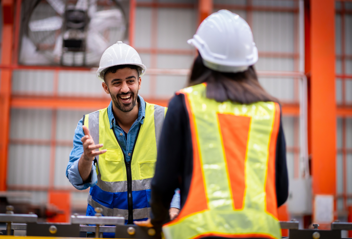 Two workers in hard hats smiling