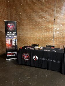 Construction Staffing Solutions Recruitment booth setup - brick wall Black table cloth construction talent - DFW veteran based company