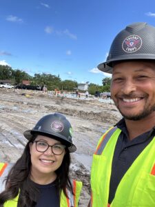 Construction jobsite visit - PPE hard hat, yellow safety vests, heavy machine operators, construction skilled labor solutions