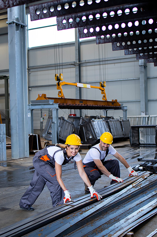 construction workers in hard hats working with large metal beams