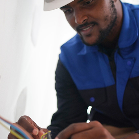 electrician in white hard hat and blue jacket