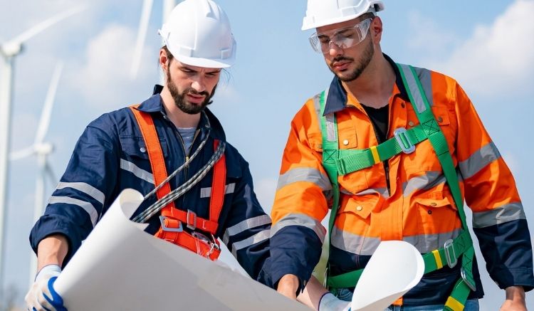 Two workers in orange vests and hard hats