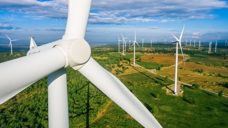many wind turbines spread out over large, vast fields