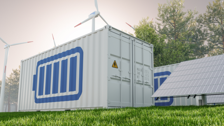 A white shipping container or battery-storage unit in a field.