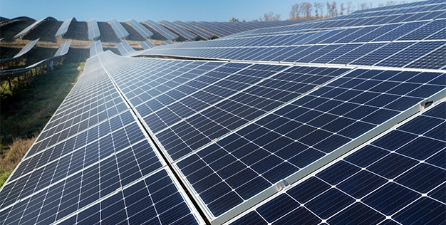Field of solar panels on a sunny day.