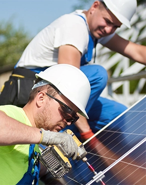 Two workers in hard hats and safety gear.