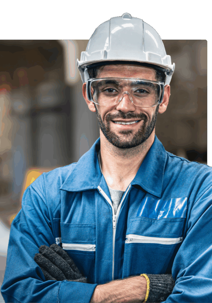 Smiling construction worker in a white hard hat and safety glasses.